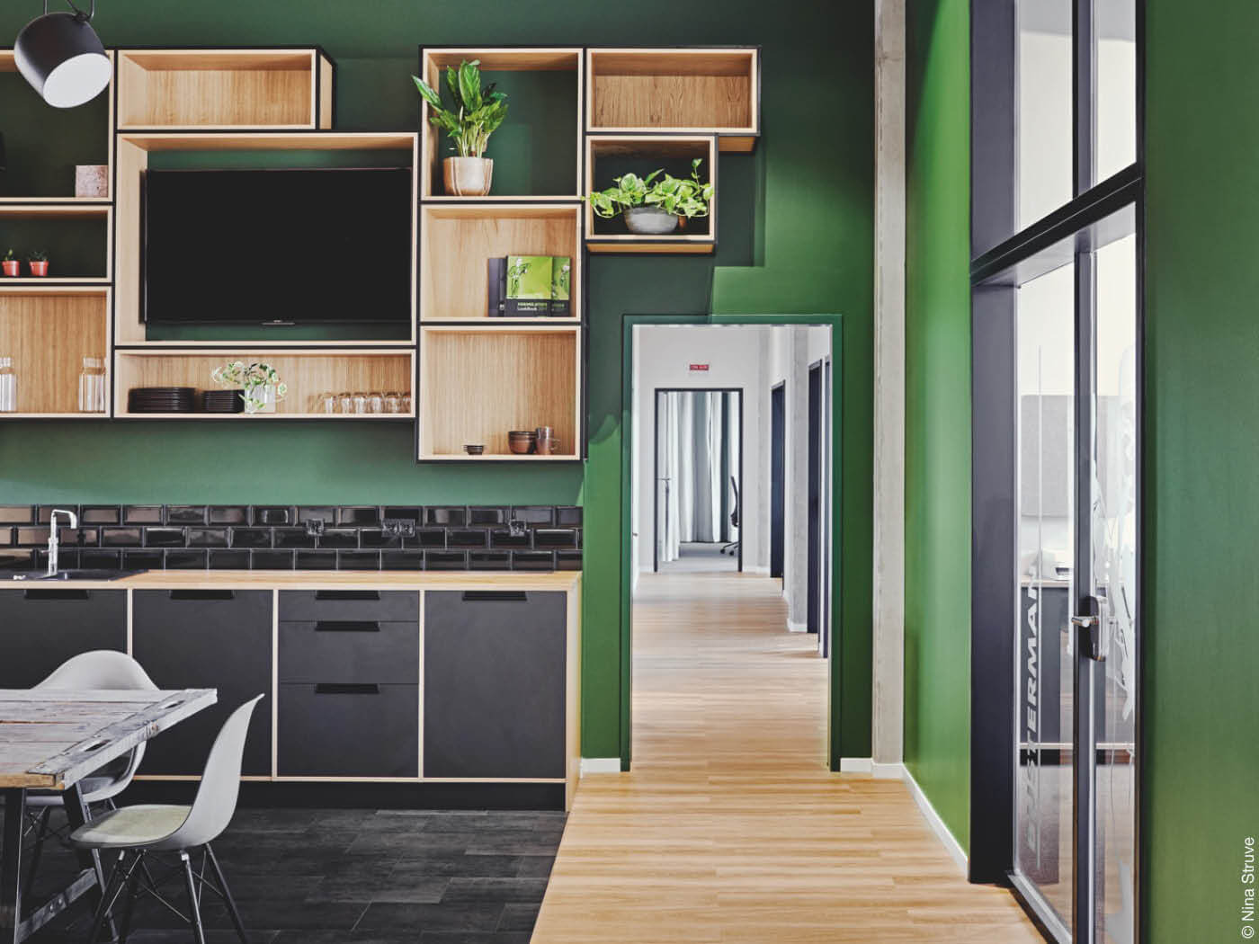 Küche mit grünen Wänden und schwarzen sowie hölzernen Applikationen