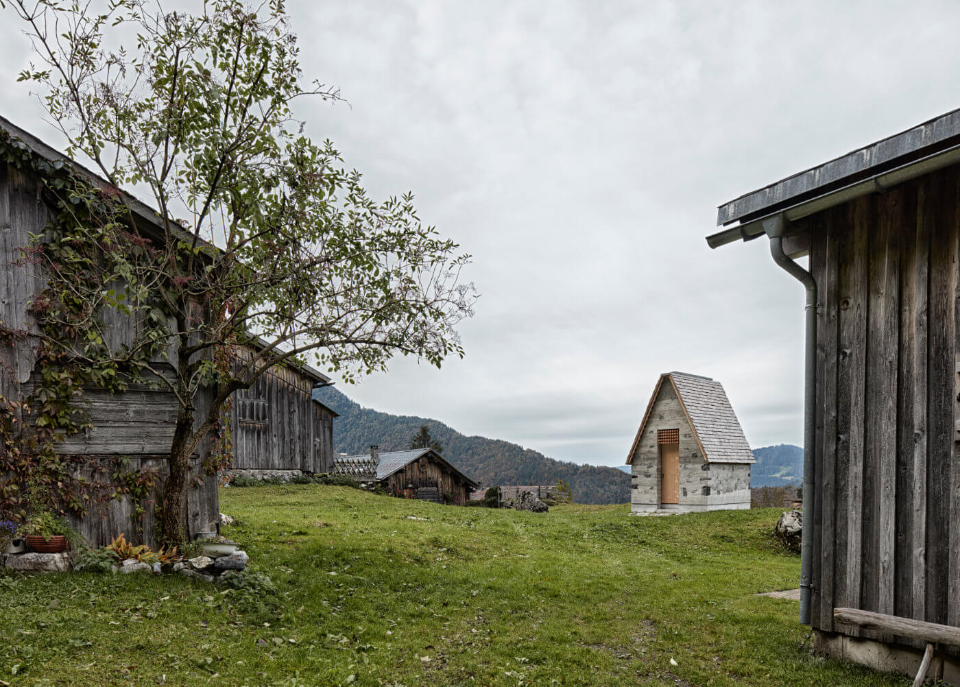 Bergkapelle und Holzhäuser auf Wiese