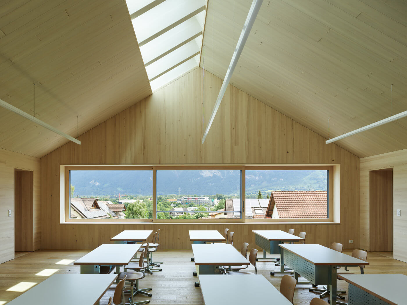 Klassenzimmer mit Holzwänden und Blick aus Fenster
