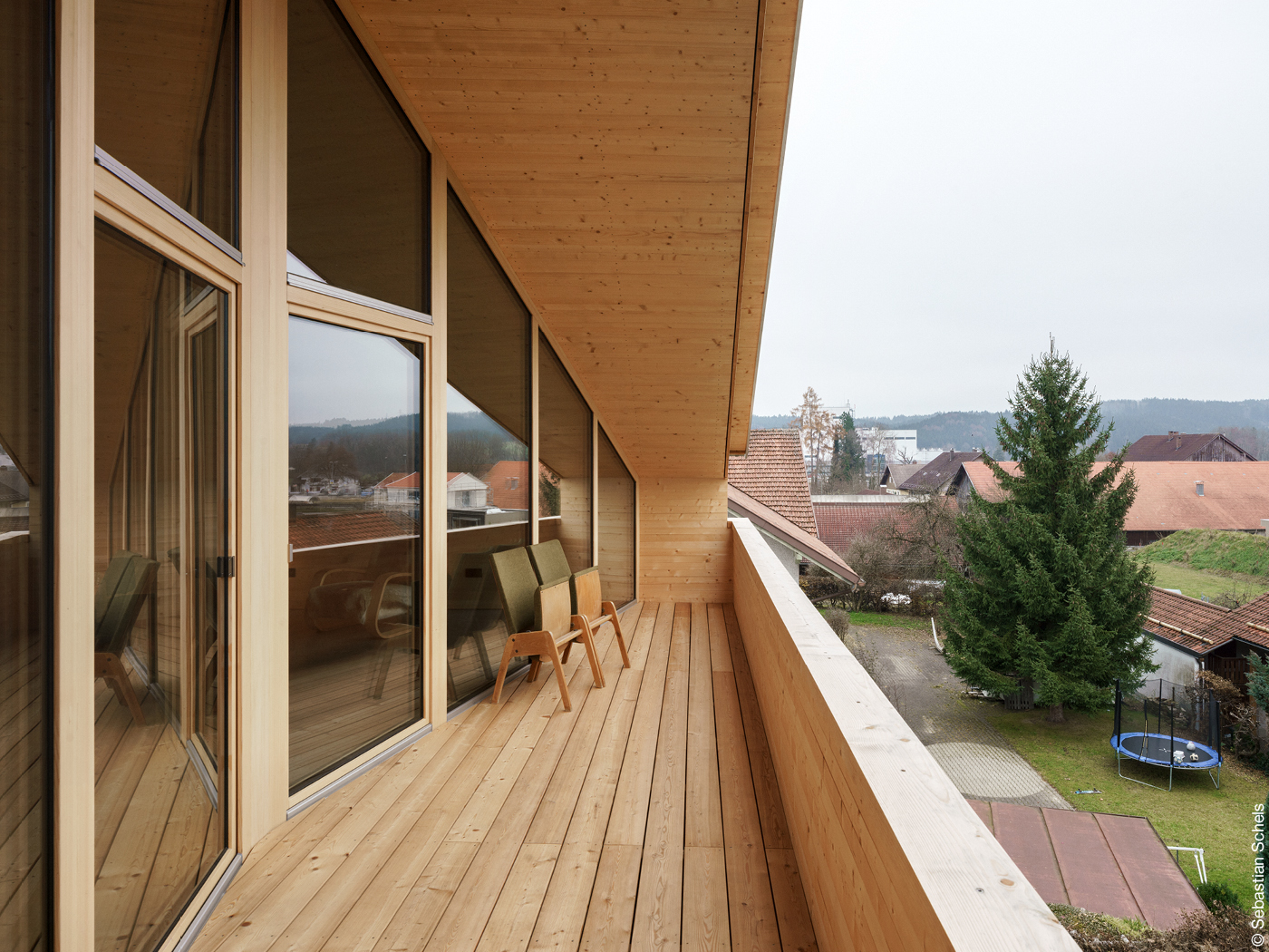 Balkon unter Spitzdach mit Holzboden und Glasfassae