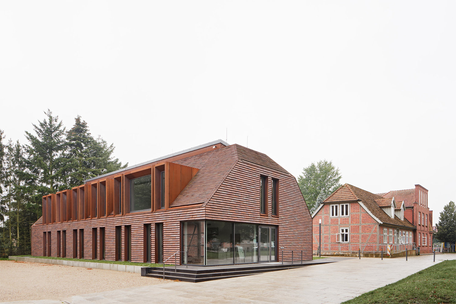 Fachwerkhaus und moderner Neubau aus Ziegeln mit Walmdach und Gauben