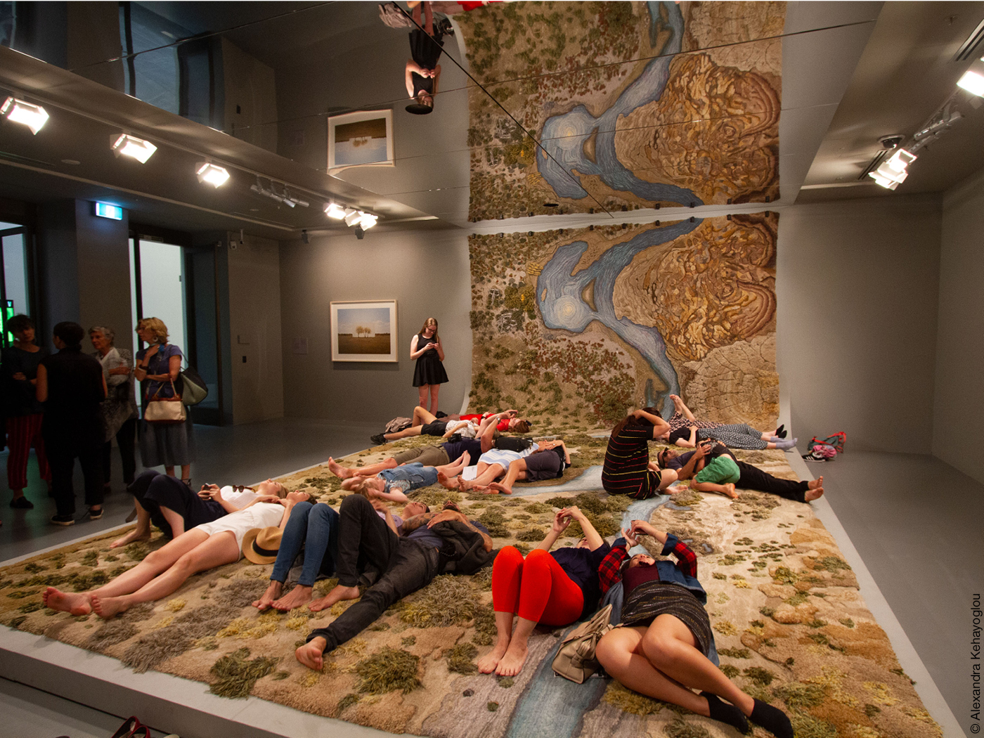 Menschen liegen auf einem Teppich mit Landschaftsmuster