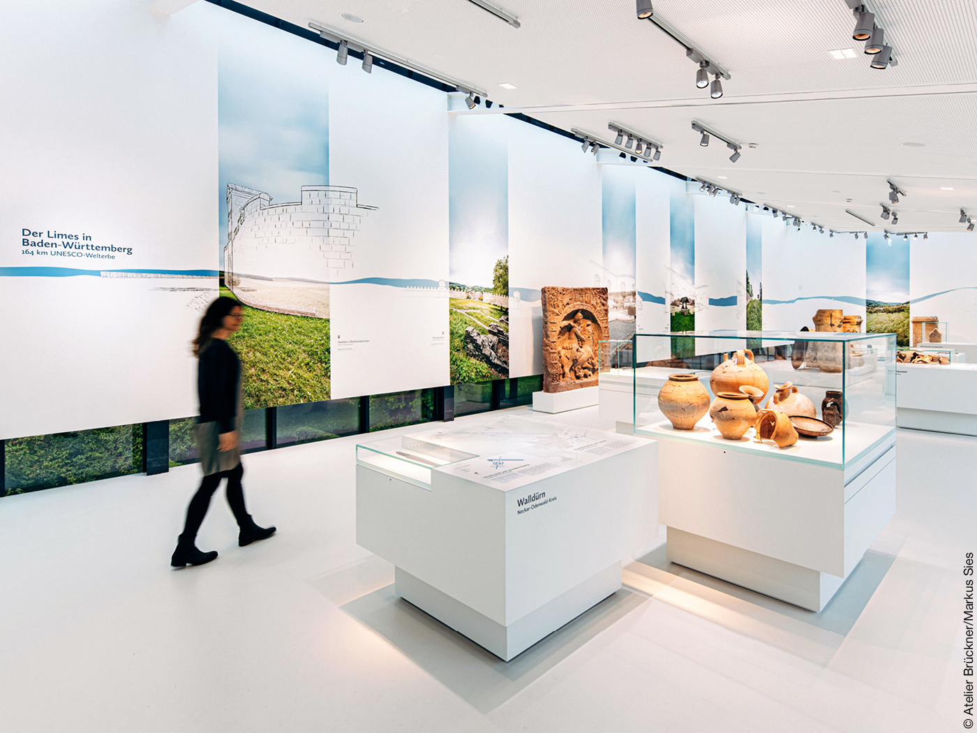 Besucherin geht durch einen Ausstellungsbereich des Limesmuseums in Aalen