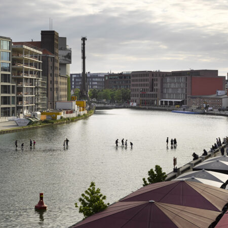 Menschen laufen über das Wasser in einem Hafenbecken