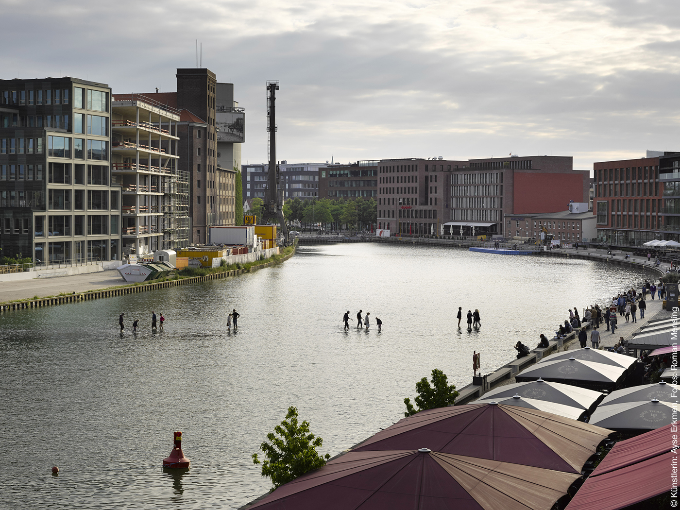 Menschen laufen über das Wasser in einem Hafenbecken