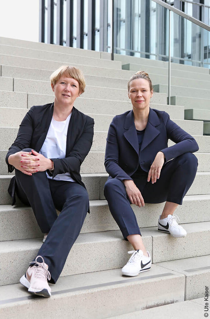 Barbara Eitner und Birte Riepenhausen von null2elf sitzen auf einer Treppe