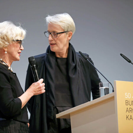 Barbara Ettinger-Brinckmann und Anne Katrin Bohle vor Rednerpult auf dem DAT 2019