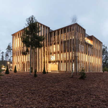 Baumstämme als Fassade an einem Holzbau