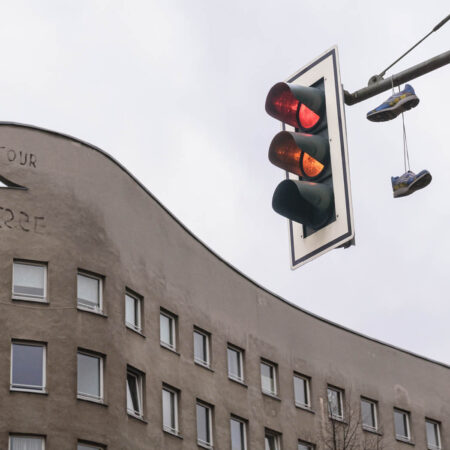 Wohnhaus mit grauer Fassade und Schriftzug Bonjour Tristesse