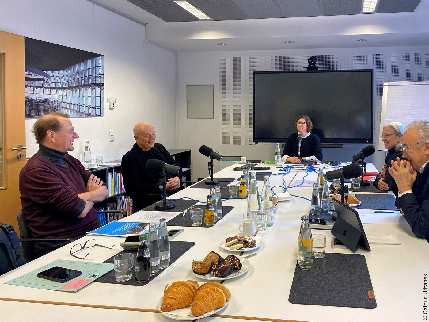 Personen bei Podcastaufnahme in Konferenzraum