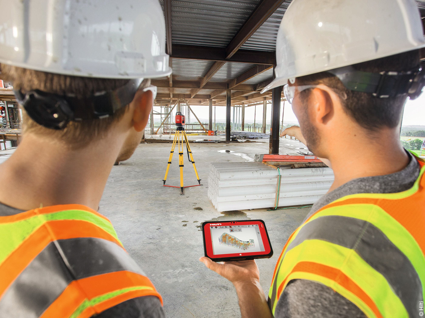 Bauarbeiter arbeiten auf Baustelle mit digitaler Bausoftware