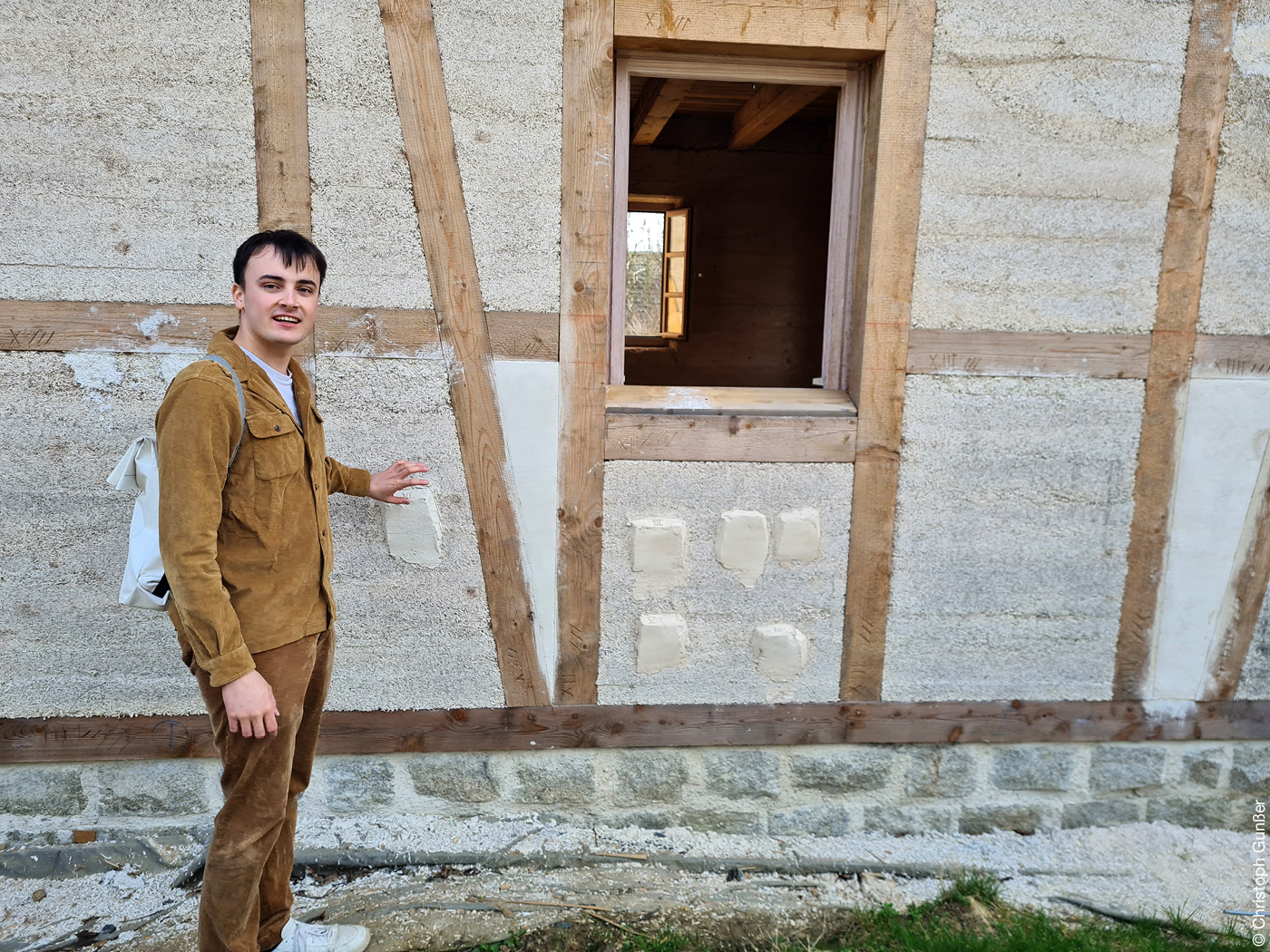 Mann vor einem Haus mit Fachwerkfassade