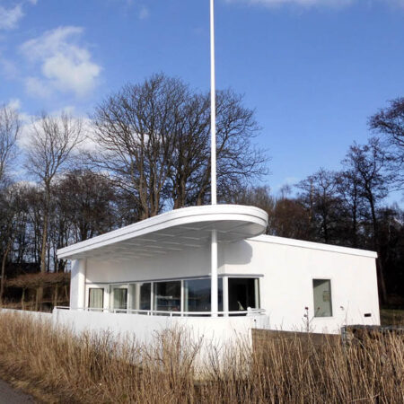 Weißes Wohnhaus mit Fahnenmast an der Kieler Förde