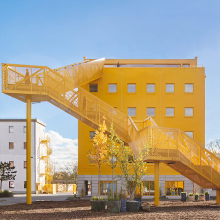 Gelbes Haus mit gelber Zugangstreppe.