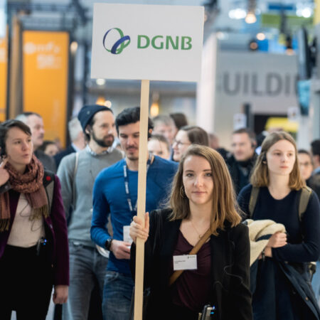 Junge Besuchergruppe auf eine Messe mit Schild der DGNB