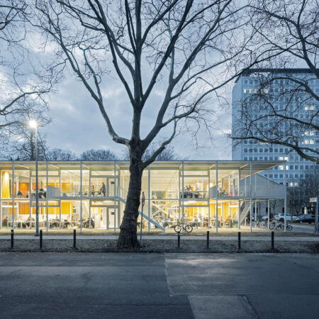 Gläserner Pavillon mit gelben Vorhängen am Abend