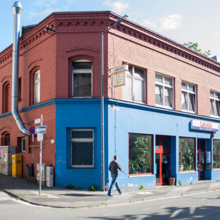 zweigeschossiger Altbau mit Backstein und blauer Fassade