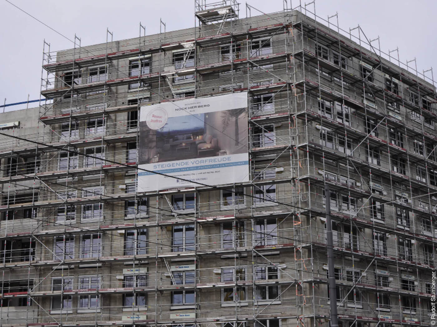 Wohnhaus mit Baugerüst und Werbung