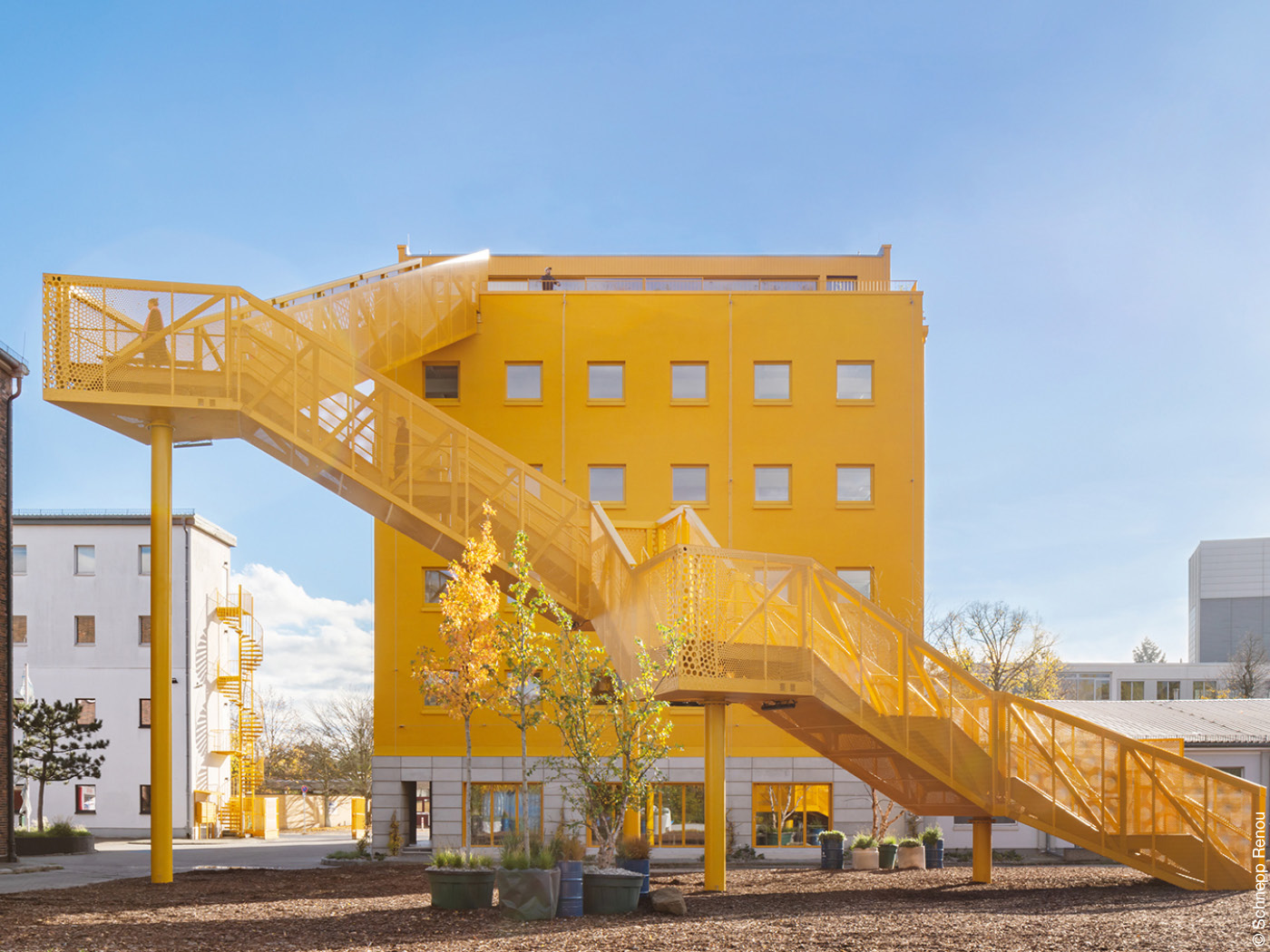 Gelbes Haus mit gelber Zugangstreppe.