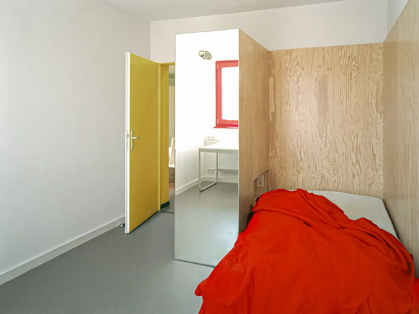 Schlafzimmer im Studentendorf Schlachtensee mit Spiegel und Holzwand