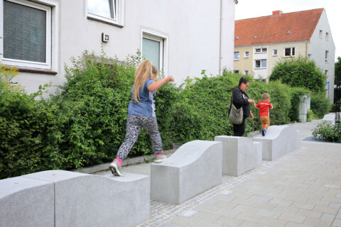 Kinder laufen in einer Stadt von Steinhügel zu Steinhügel