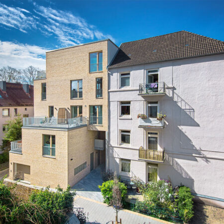 Altbau mit neuem Anbau aus hellen Klinkern