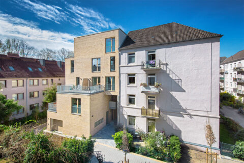 Altbau mit neuem Anbau aus hellen Klinkern