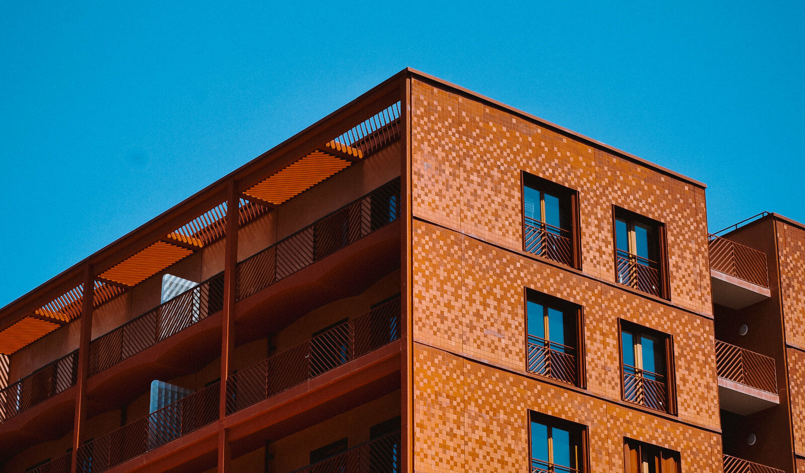 Wohnhaus im Olympischen Dorf in Paris mit roter Fliesen-Fassade