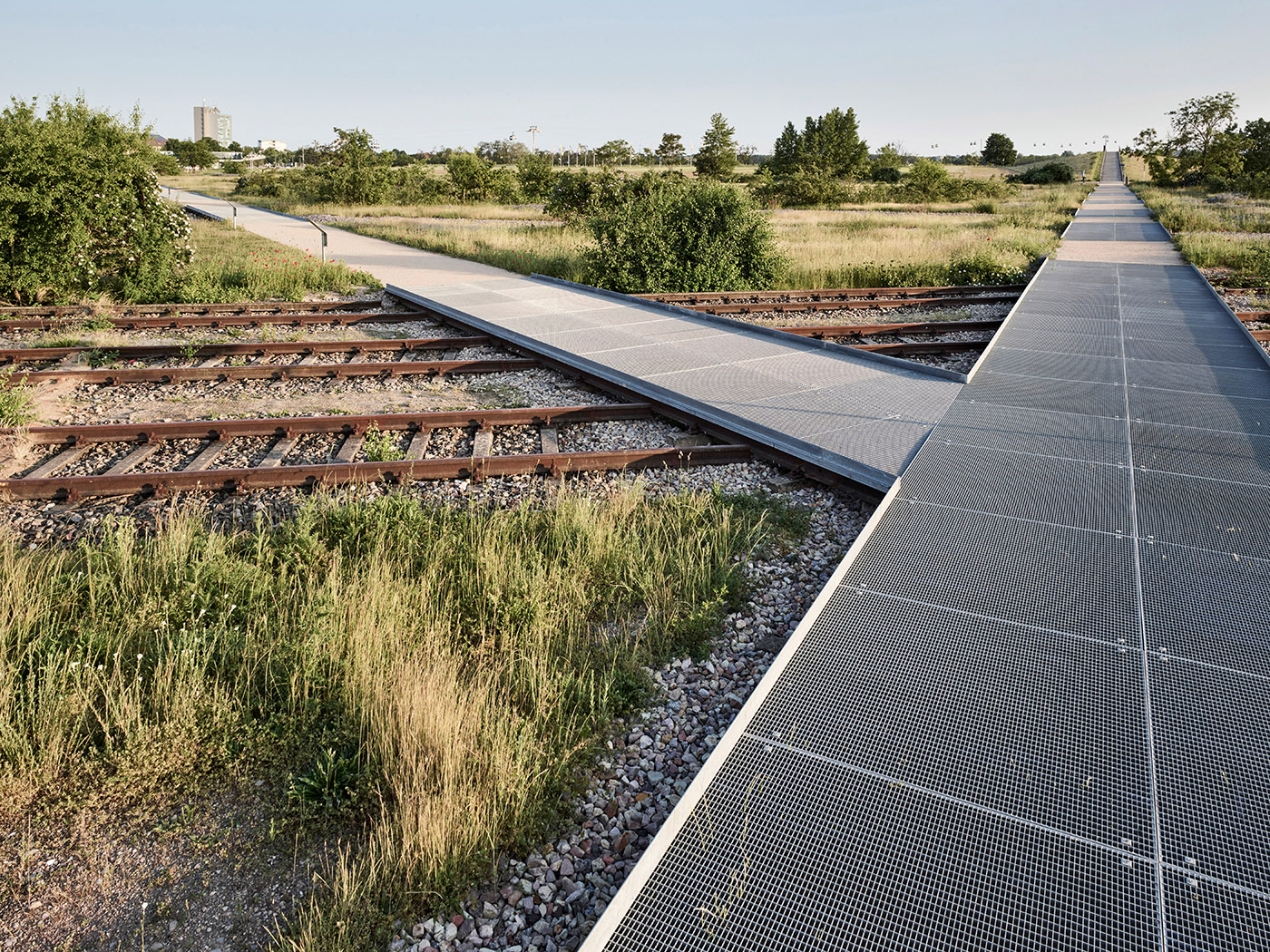 Naturbelassener Park mit Stegen über Bahngleisen