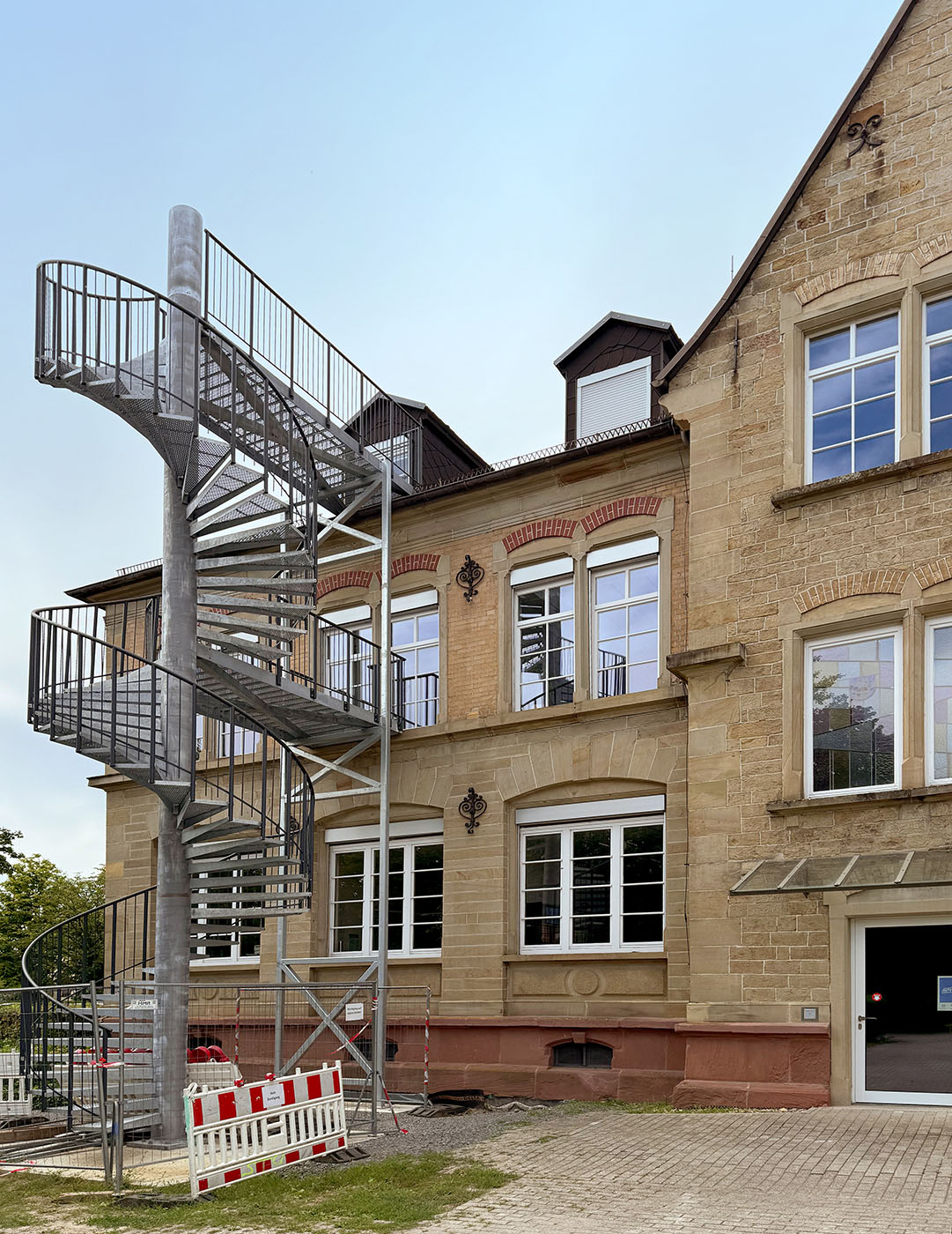 Gebäude mit Sandsteinen und wuchtiger Fluchttreppe