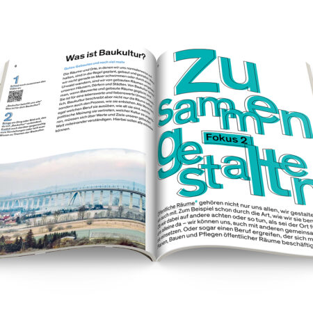 Aufgeschlagenes Schulbuch der Bundesstiftung Baukultur, zu sehen ist ein Text mit einer mintgrünen Überschrift und einem Foto von einer Brücke, die über Felder führt.