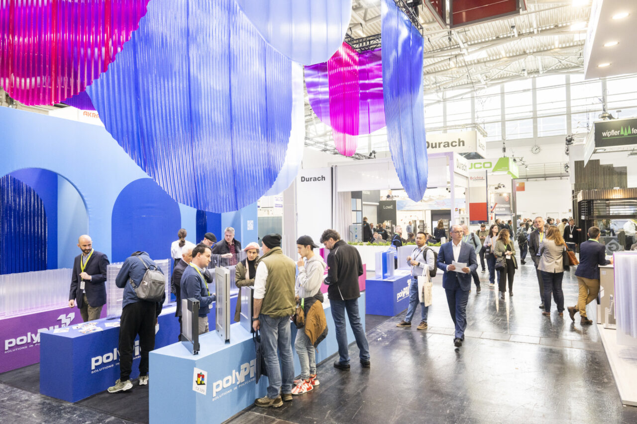 Messestand auf der Messe Bau mit violetten Möbeln und von der Decke hängenden Kreisen