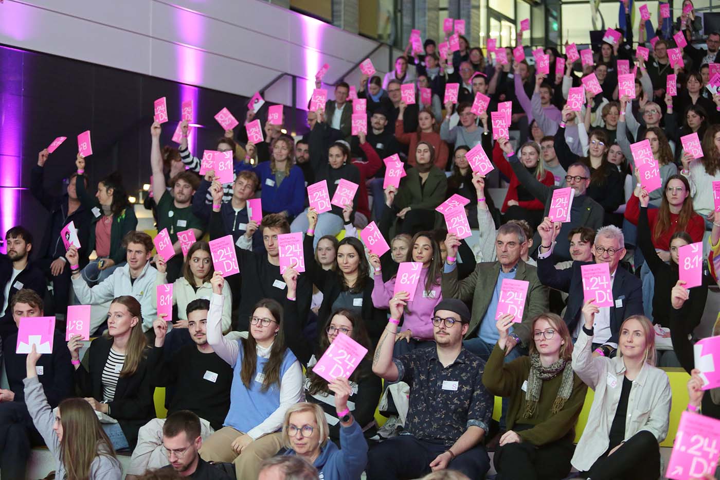 Publikum auf dem Nachwuchsarchitektentag bei Abstimmung mit rosa Karten