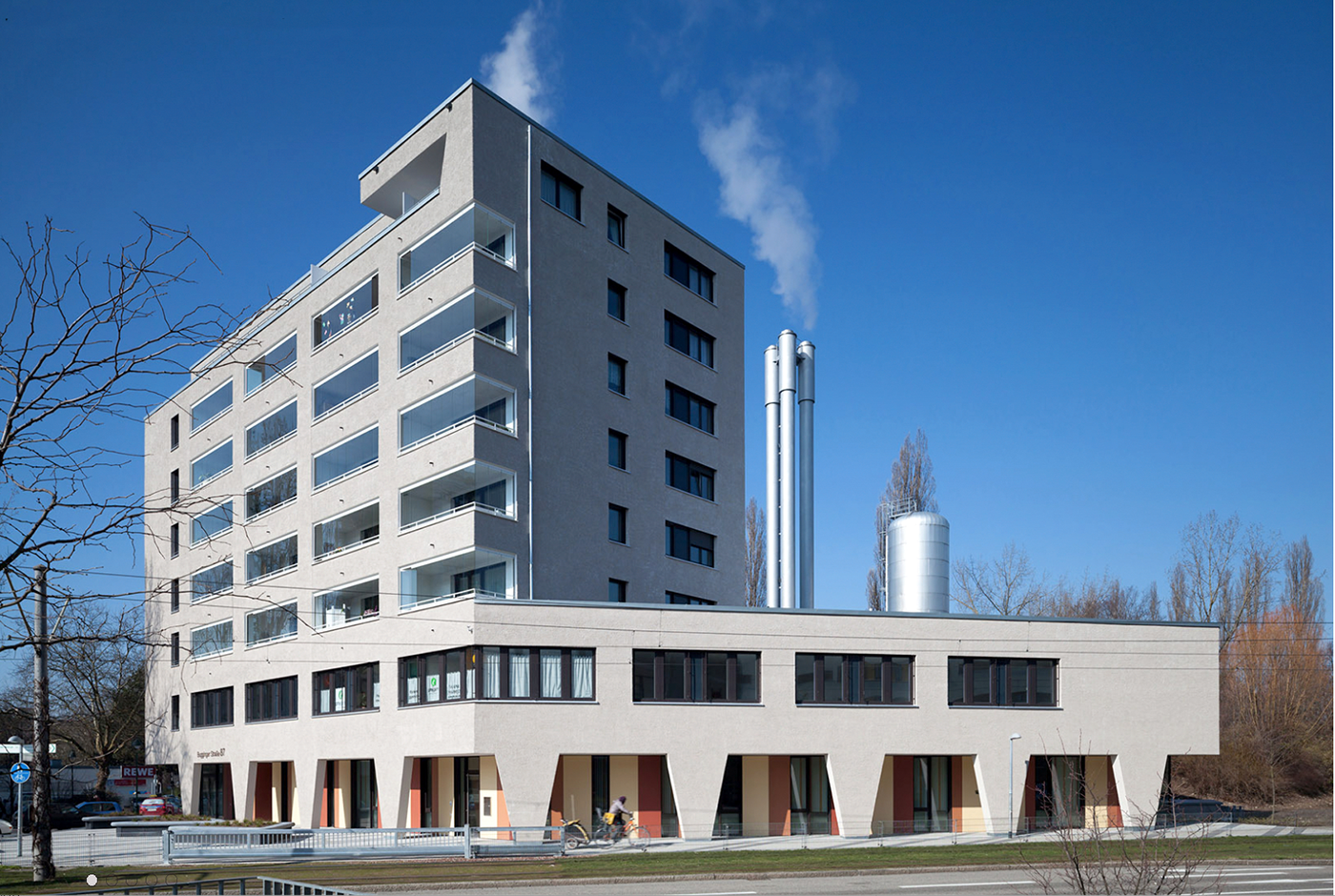 Hellgrauer Plattenbau der Wohnsiedlung Stadtteil Weingarten-West in Freiburg, der sich einem blauen Himmel entgegen reckt.