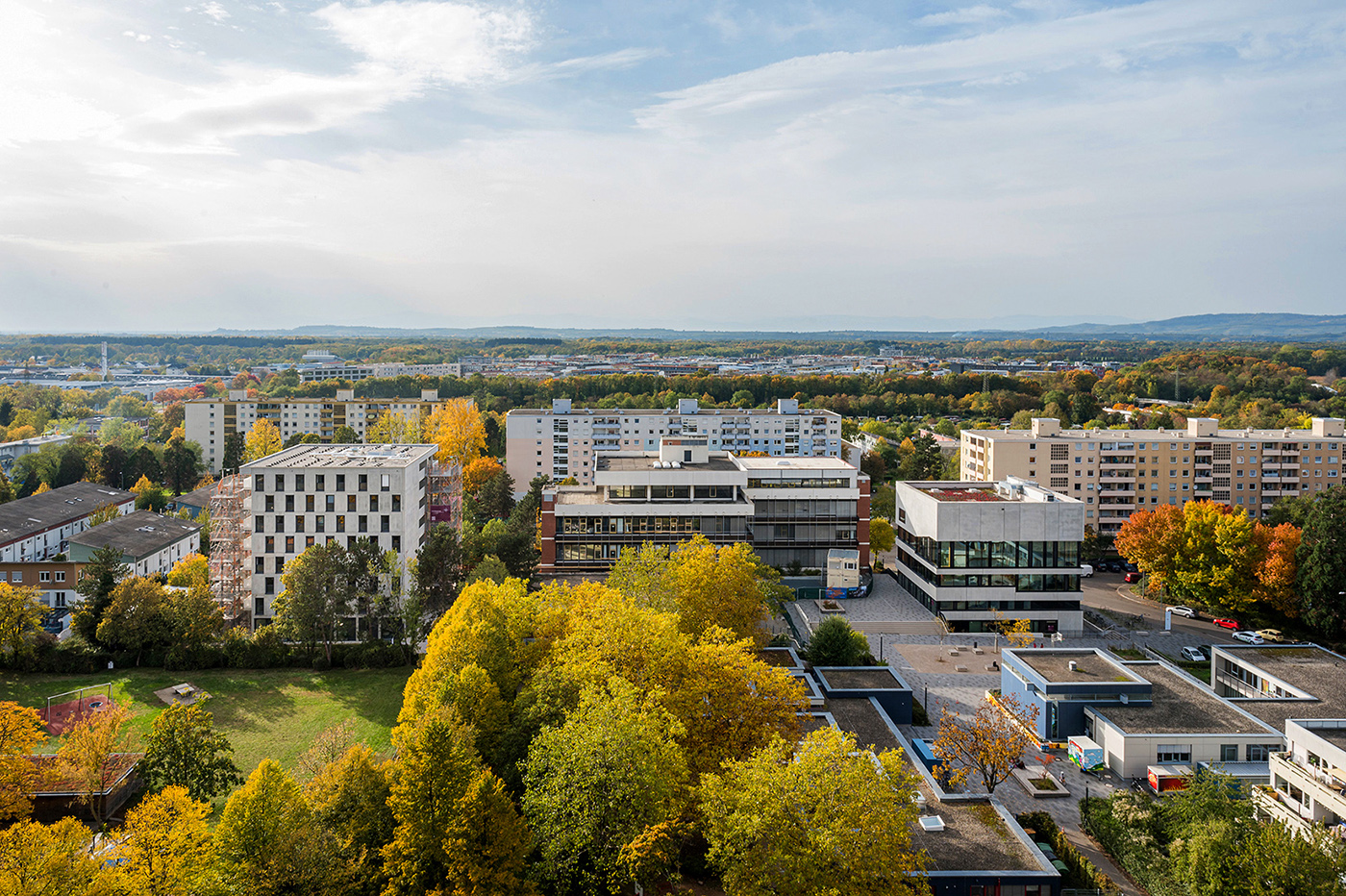 Campus der Evangelischen Hochschule in Freiburg mit Hochhäusern und herbstbunten Bäumen.