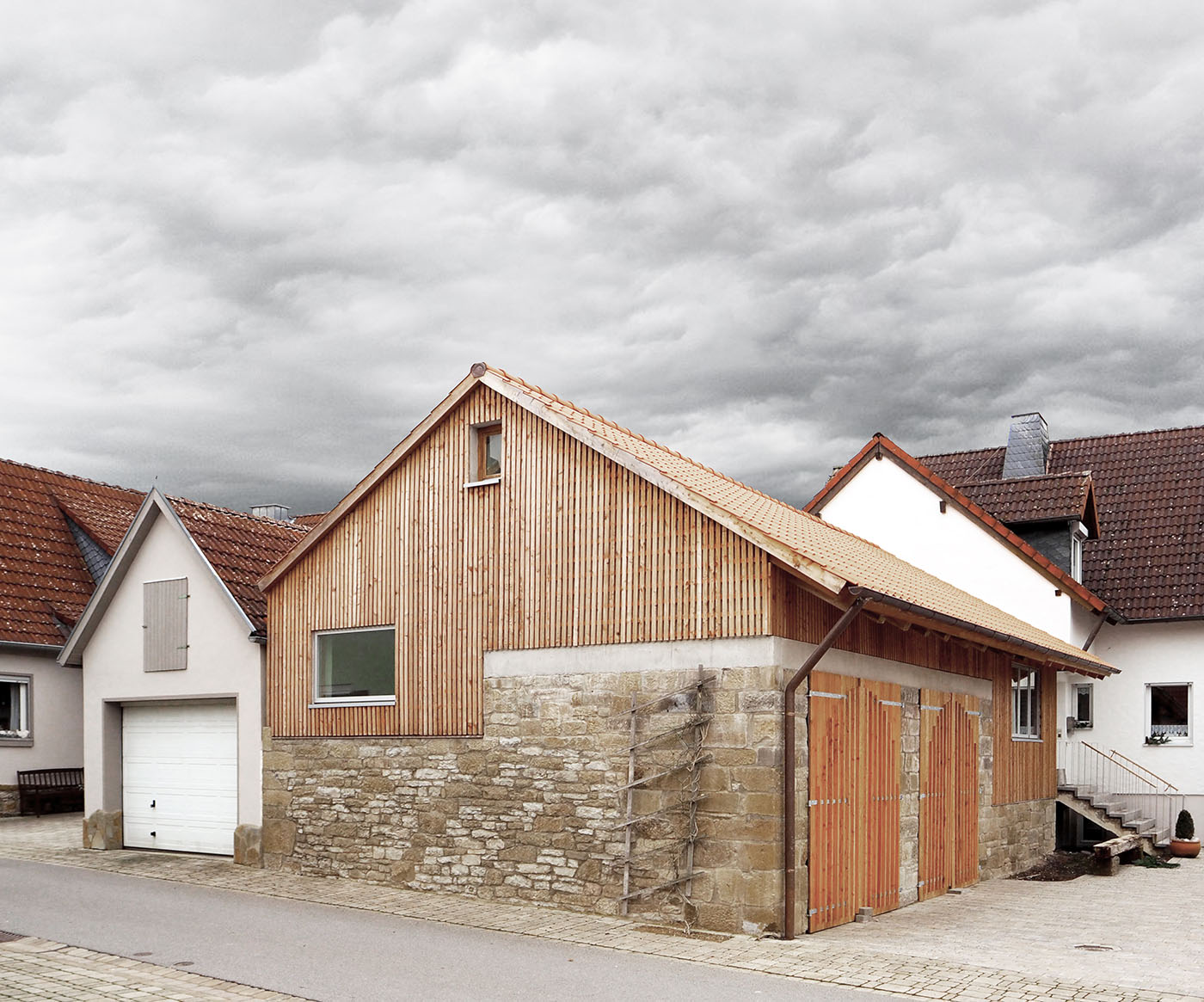 Bauernhaus mit Sandtsienmauer und neuem Dach mit Holzverkleidung